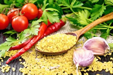 Bulgur in spoon on table Stock Photos