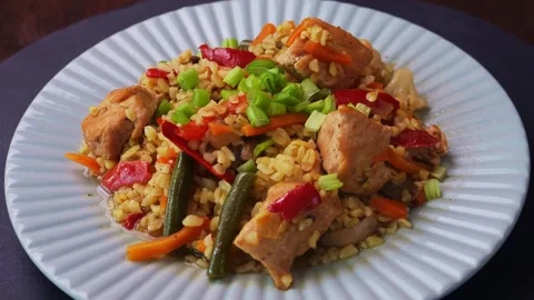 Bulgur with stewed meat and vegetables in grey tpeel rotating in a circle t.. 库存影片 307716699