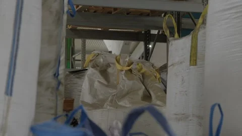 Bulk bags of material stored on warehouse racks in recycling factory Stock Footage 337913262