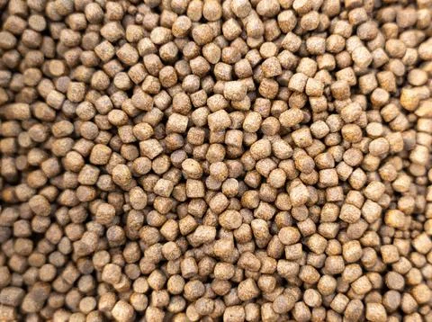 Bulk brown food pellets of different sizes and same form Stock Photos