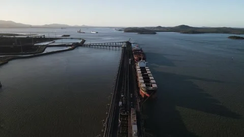 Bulk cargo ships docked at an industrial port loading facility within the Stock Footage 329099492