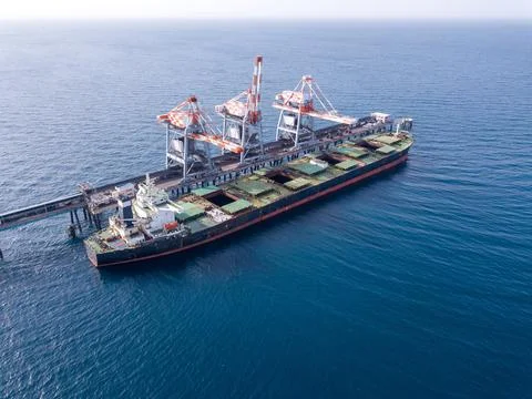 Bulk container ship unloads coal in the port of power station. Stock Photos
