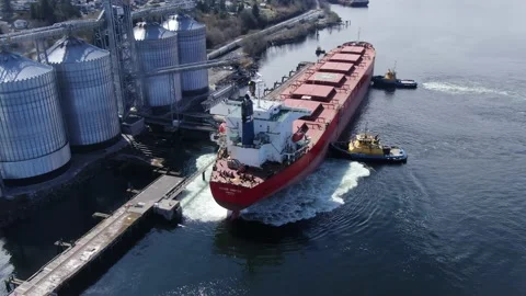 Bulk freighter Navios Orbiter engines in reverse docking with tug boats 4K drone Stock Footage 149137656