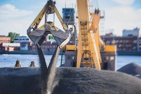 Bulk-handling crane unloading sand, road metal and gravel from cargo vessel s Stock-Fotos