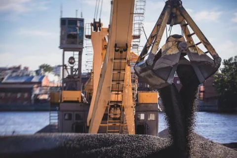 Bulk-handling crane unloading sand, road metal and gravel from cargo vessel s 库存照片