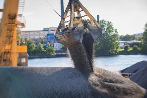 Bulk-handling crane unloading sand, road metal and gravel from cargo vessel s Stock Photos