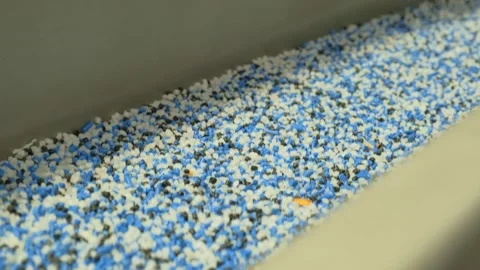 Bulk polymer mixture flowing through industrial chute indoors Vídeo Stock 342604190