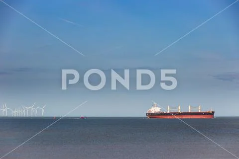 A bulker ship is followed by a pilot boat Stock Photos