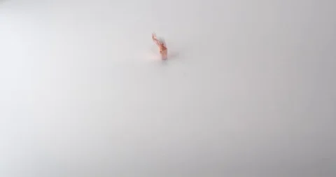 Bulldog clips fall onto a white table top Stock Footage 117349484