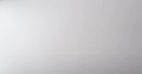 Bulldog clips fall onto a white table top Stock Footage 117349497