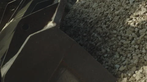 Bulldozer bucket loading stone pieces from pile, crushing machine, quarry work Video stock 294065689