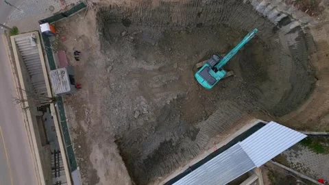 A bulldozer is digging a pit for the construction of another building in the Stock Footage 270222934