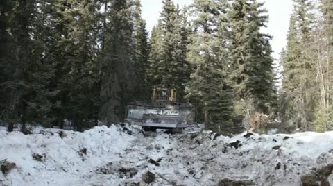 Bulldozer driving down a snow covered road on a gold mine in Alaska Stock Footage 10885194