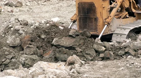 Bulldozer efficiently clearing and moving a large quantity of loose rocks in a Stock Footage 52880753