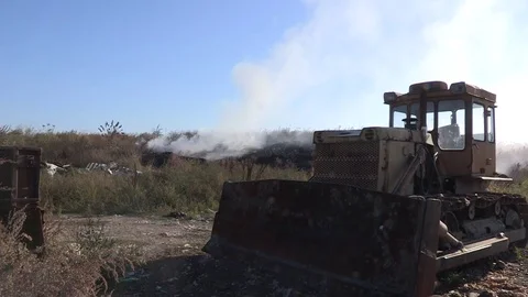 Bulldozer on garbage dump. Smoke on the background. Vídeos de archivo 71377630