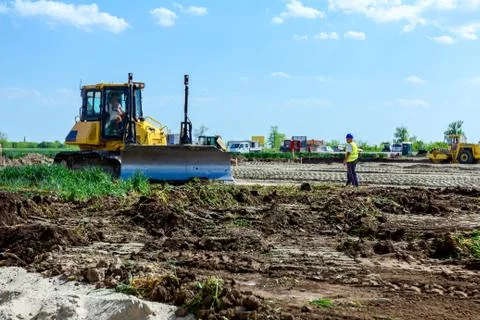 Bulldozer is leveling ground at construction site Stock Photos