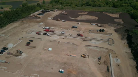A bulldozer levels a plot of land for construction suite development. Wide shot Vídeos de archivo 245526194