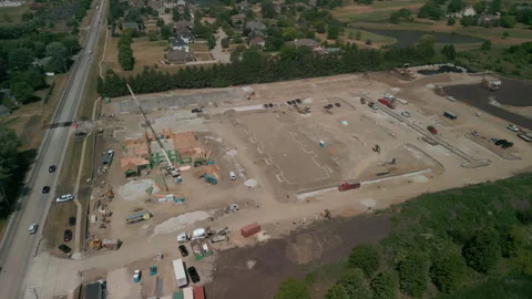 A bulldozer levels a plot of land for construction suite development. Wide Stock Footage 245752337