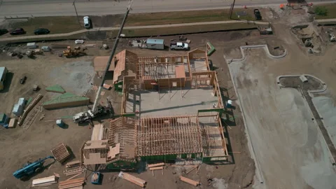 A bulldozer levels a plot of land for construction suite development. Drone Stock Footage 245753074