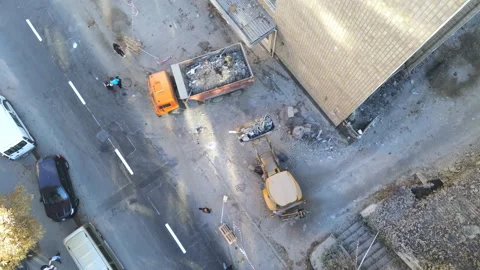 Bulldozer loader uploading waste and debris into dump truck Stock Footage 115493877