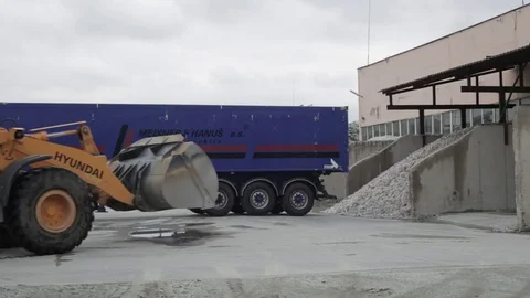 Bulldozer loads garbage from depot cell and pours it into a trailer Stock Footage 72857889