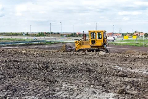 Bulldozer machine is leveling construction site Stock Photos