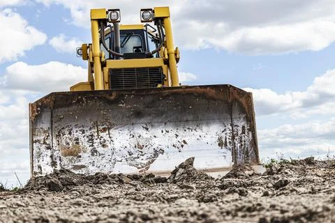 Bulldozer machine is leveling construction site. Photos