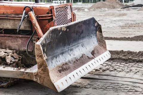 Bulldozer machine is leveling construction site. Earthmover with caterpillar Stock Photos