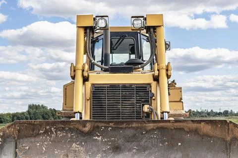 Bulldozer machine is leveling construction site. Stock Photos