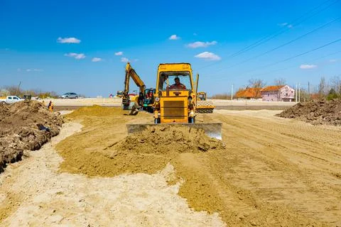 Bulldozer machine is leveling construction site. Stock Photos