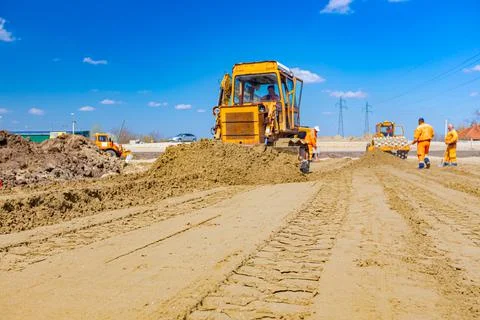 Bulldozer machine is leveling construction site. Stock Photos
