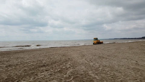 Bulldozer Moving Forward On Beach With Waves And Cloudy Sky Stock Footage 121201675