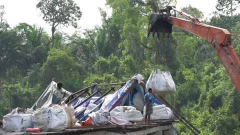 A bulldozer is moving material prepared by workers on a stilt bridge under .. 库存影片 232699659