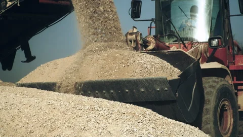 Bulldozer operator loading stone pieces, transportation in open pit of quarry Stock Footage 294088706