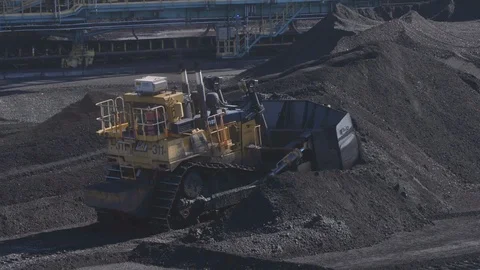 Bulldozer pushing coal through coal piles Stock-Footage 103347798