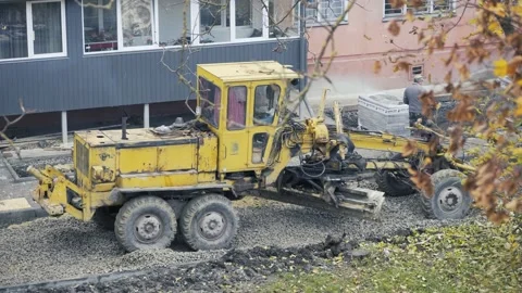 Bulldozer repairs the road in the yard Stock Footage 147861906