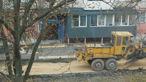 Bulldozer repairs the road in the yard Video stock 147863603