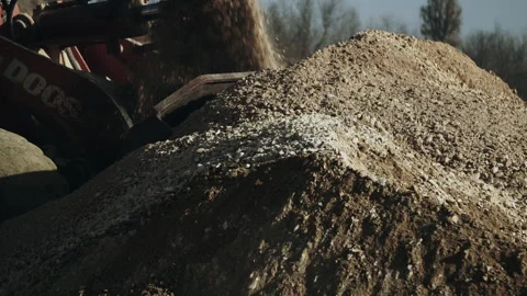 Bulldozer scoop loading and transporting crushing stone pieces in quarry closeup Video stock 294079570