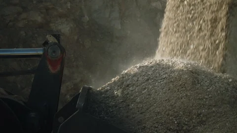 Bulldozer scoop loading falling rock pieces from crushing machine in stone pit Video stock 293968091