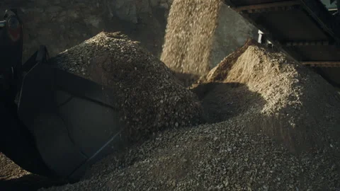 Bulldozer scoop loading rock pieces for road work, crushing machine in stone pit Video stock 293963122