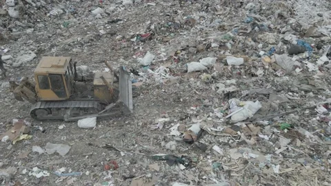 Bulldozer tractor pushes garbage from a mountain in a city dump Stock-Footage 145720913
