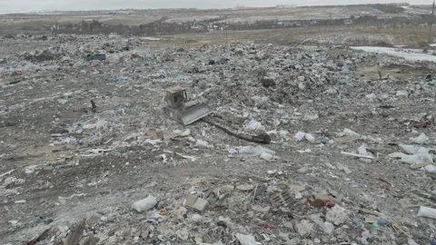 Bulldozer tractor pushes garbage from a mountain in a city dump Stock-Footage 147400345