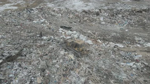 Bulldozer tractor pushes garbage from a mountain in a city dump Stock-Footage 147400363