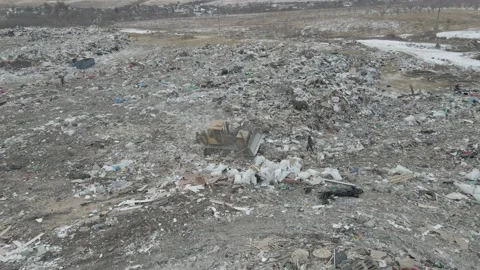 Bulldozer tractor pushes garbage from a mountain in a city dump Stock-Footage 147400506