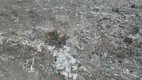 Bulldozer tractor pushes garbage from a mountain in a city dump Stock-Footage 147400574