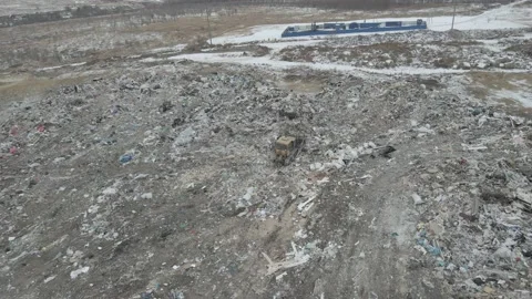 Bulldozer tractor pushes garbage from a mountain in a city dump Stock-Footage 147400608