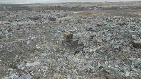 Bulldozer tractor pushes garbage from a mountain in a city dump Stock-Footage 147401285