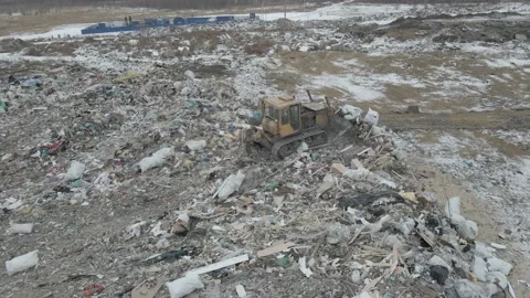 Bulldozer tractor pushes garbage from a mountain in a city dump Stock-Footage 147401476