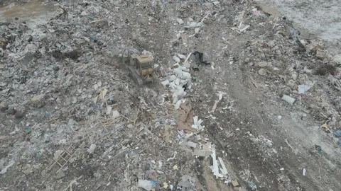 Bulldozer tractor pushes garbage from a mountain in a city dump Stock-Footage 148657183