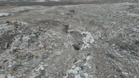 Bulldozer tractor pushes garbage from a mountain in a city dump Stock-Footage 148657275